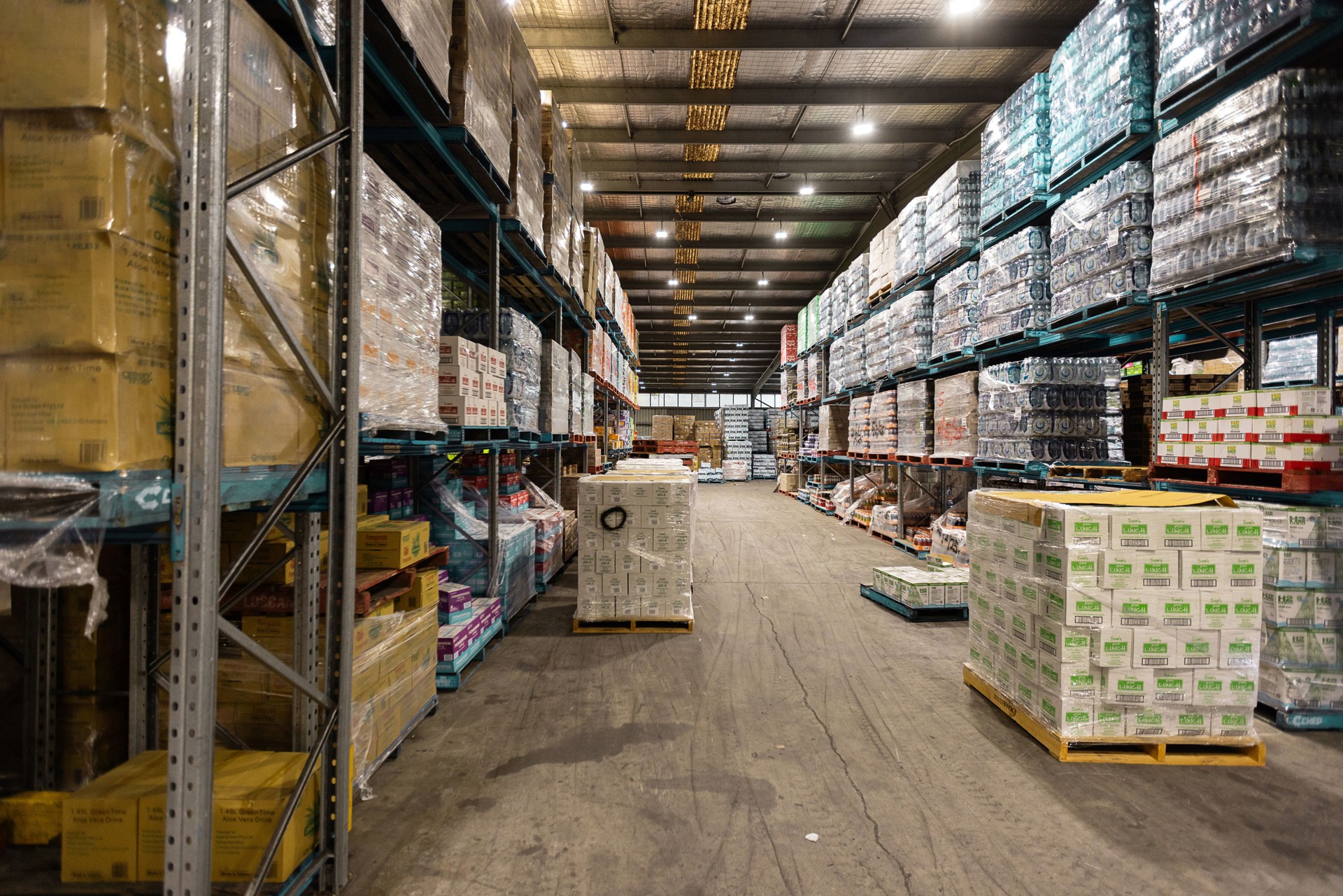 Large Warehouse Interior with Stacked Goods and Palletized Boxes